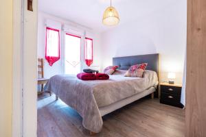 a bedroom with a large bed with red curtains at Appartement Cool Montagne in Briançon