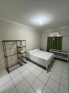 a bedroom with a bed and a green curtain at Casa no pavimento superior in São Luís
