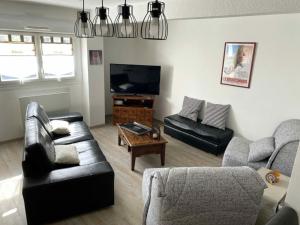 a living room with a couch and a tv at Appartement Cool Montagne in Briançon +3 photos