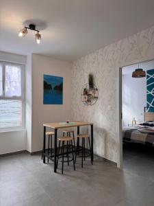 a dining room with a table and chairs and a bed at 104 - centre de voiron - DeTassigny in Voiron