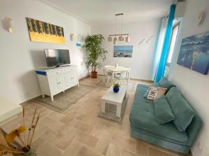 a living room with a green couch and a tv at La Casina di Perla in Viareggio