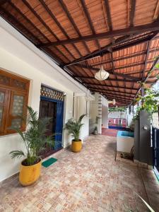 an indoor patio with plants and a wooden ceiling at L'EDELWEISS Heritage House in Pondicherry