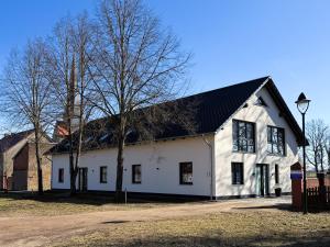 a large white building with a black roof at Kraatzer Ferienwohnungen in Gransee
