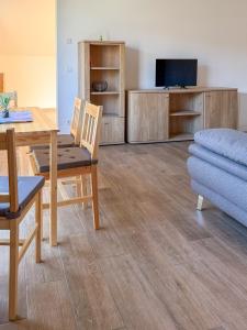 a living room with a dining table and a tv at Kraatzer Ferienwohnungen in Gransee