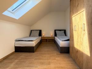 two beds in a room with a skylight at Kraatzer Ferienwohnungen in Gransee