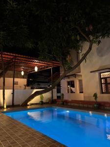 a large blue swimming pool in a building at night at L'EDELWEISS Heritage House in Pondicherry