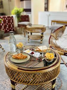 a table with a tray of breakfast food on it at L'EDELWEISS Heritage House in Pondicherry