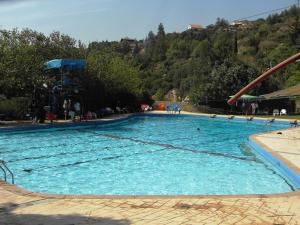 a large pool of blue water with a slide at קצה ההר in Amirim