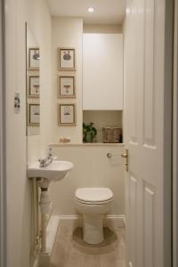 a bathroom with a white toilet and a sink at Central Village Cottage, The Corders in Moreton in Marsh +25 photos
