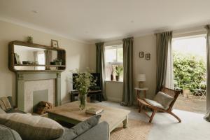a living room with a couch and a fireplace at Central Village Cottage, The Corders in Moreton in Marsh