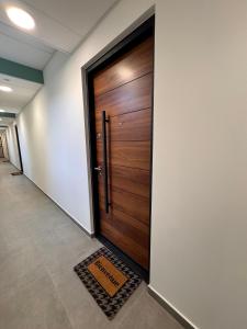 a wooden door in a hallway with a welcome mat at 104 - centre de voiron - DeTassigny in Voiron