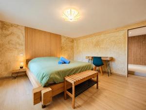 a bedroom with a bed and a bench in it at Voyage éco-responsable Immersion nature Wifi in Belleydoux
