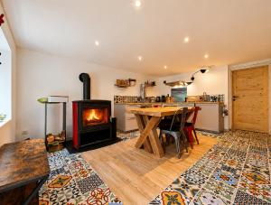 a living room with a wooden table and a fireplace at Voyage éco-responsable Immersion nature Wifi in Belleydoux