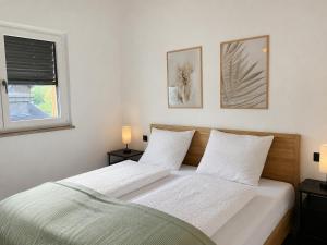 two beds in a bedroom with two lamps and a window at Hafenapartments Segelschule Mondsee in Mondsee