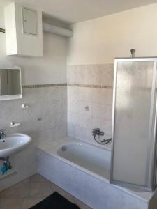 a bathroom with a bath tub and a sink at Arnold Apartments 2 in Glauchau