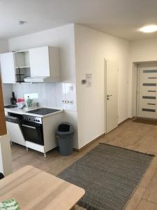 a kitchen with white cabinets and a black stove top oven at Arnold Apartments 2 in Glauchau