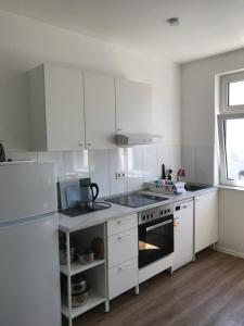 a kitchen with white cabinets and a stove top oven at Arnold Apartments 2 in Glauchau