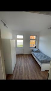 a bedroom with a bed and two windows at Arnold Apartments 2 in Glauchau
