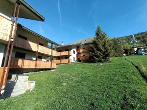 a building with a grassy yard next to a building at Le Rondinelle in Champoluc +14 photos