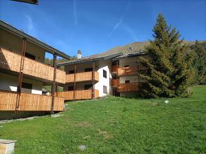 an apartment building with a tree in the yard at Le Rondinelle in Champoluc