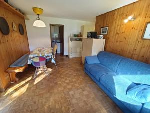 a living room with a blue couch and a table at Le Rondinelle in Champoluc