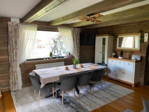 a dining room with a table and chairs at Moonlake Chalet in Găineşti