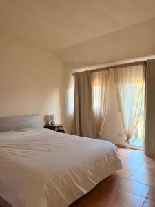 a bedroom with a white bed and a window at Kiki's Langhe House in Castagnole Lanze