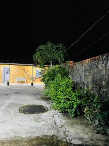 a wall with trees and a bench in front of a building at Meu aconchego in Castanhal +6 photos