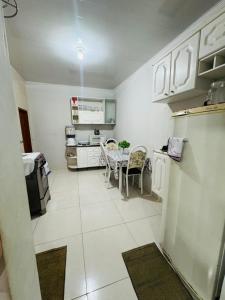 a kitchen with a table and chairs in a room at Meu aconchego in Castanhal