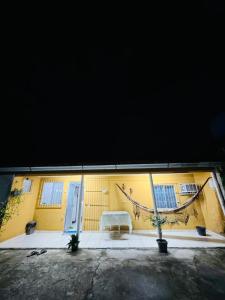 a yellow building with a bench in front of it at Meu aconchego in Castanhal