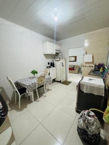 a room with a table and chairs and a kitchen at Meu aconchego in Castanhal