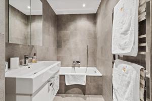 a bathroom with a white sink and a tub at Apartment in Sankt Moritz in St. Moritz +23 photos