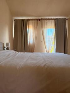 a bedroom with a white bed and a window at Kiki's Langhe House in Castagnole Lanze