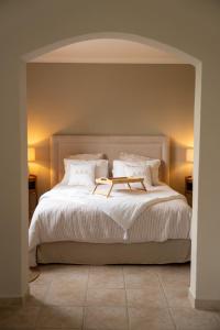 a bedroom with a large bed with white sheets and pillows at Le Castelas - Suite Calisson in Aurons