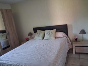 a bedroom with a white bed with two pillows at Maison de vacances en Corrèze in Saint-Pardoux-lʼOrtigier
