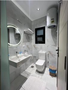 a white bathroom with a sink and a toilet at Regal View Residences & Suites in Cairo +23 photos