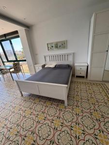 a bedroom with a large bed and a carpet at Angolina Apartments in Birżebbuġa