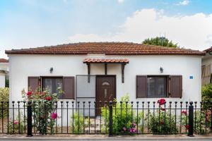 a small white house with a black fence at Bella Garden House in Ierissos +9 photos