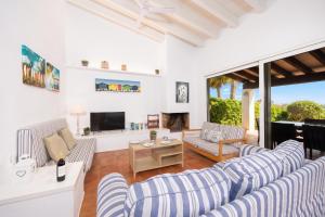 a living room with two blue and white striped couches at Villa Binipaco in Binibeca