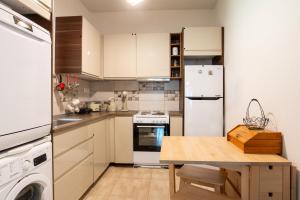a kitchen with white appliances and a wooden table at Bella Garden House in Ierissos