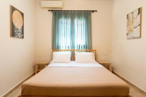 a bedroom with a large bed with a window at Bella Garden House in Ierissos