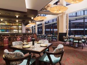 a restaurant with tables and chairs and a bar at Novotel Kolkata Hotel and Residences in Kolkata