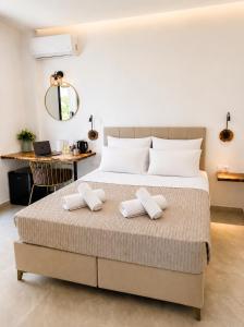 a bedroom with a bed with two towels on it at Maxa Residences - Free Airport Shuttle in Artemida