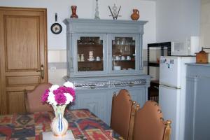 a blue cabinet with a vase of flowers on a table at gite les beaudries in Rilly-sur-Loire