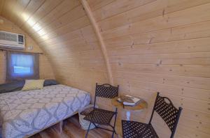 a room with a bed and two chairs in a cabin at The Cranny at Kimberly Creek Retreat in Ashland