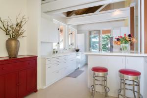a kitchen with white cabinets and red bar stools at Mountain Mid Century in Sun Valley +36 photos