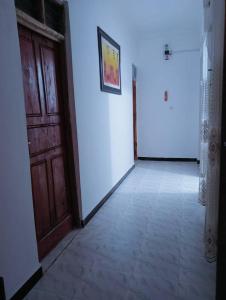 a hallway with a wooden door and a white wall at bed and breakfast in Kidoti