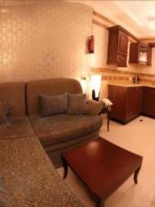 a living room with a couch and a table at اجنحة الخزامى المخدومة in Yanbu