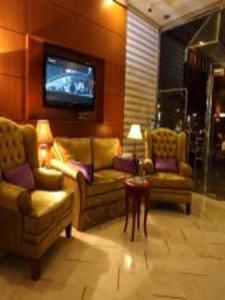 a living room with two couches and a tv at اجنحة الخزامى المخدومة in Yanbu