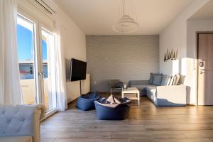 a living room with a couch and a tv at White Rock Milos Suites in Adamantas